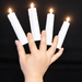 Four lit multiplying candles held between fingers